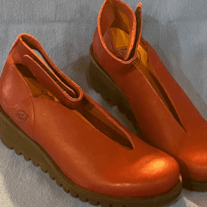 Stylish red shoes on blue background
